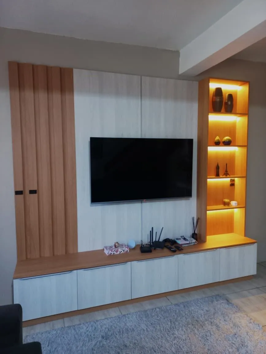 Painel de TV planejado com nicho iluminado na sala