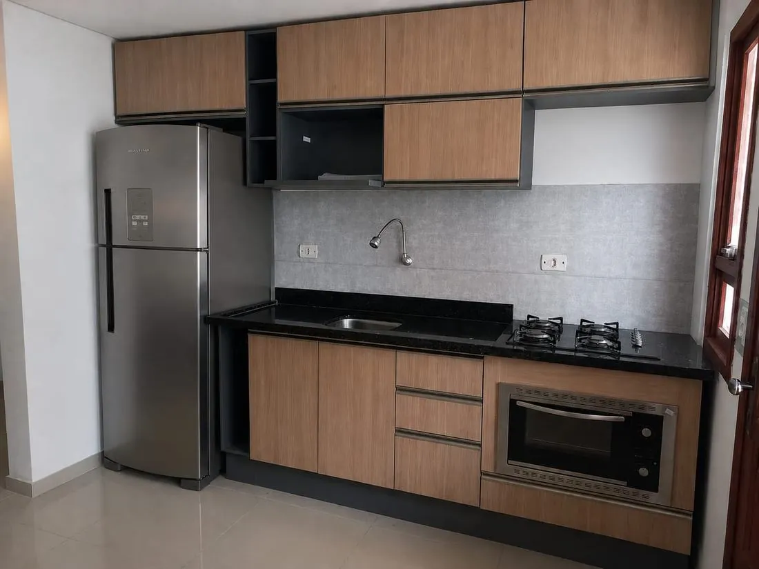 Cozinha planejada amadeirada com nichos pretos e bancada de granito